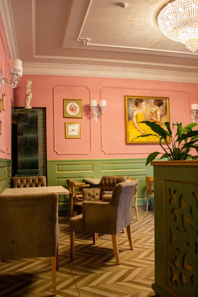 Charming indoor cafe featuring vintage decor, pink and green walls, and cozy seating.